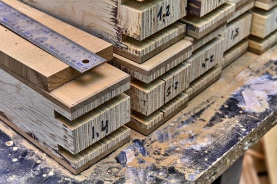 Processed lvl timber beams with precision cuts and ruler measurement for building projects