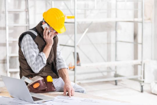 Site supervisor reviewing plans beside kwikstage scaffolding