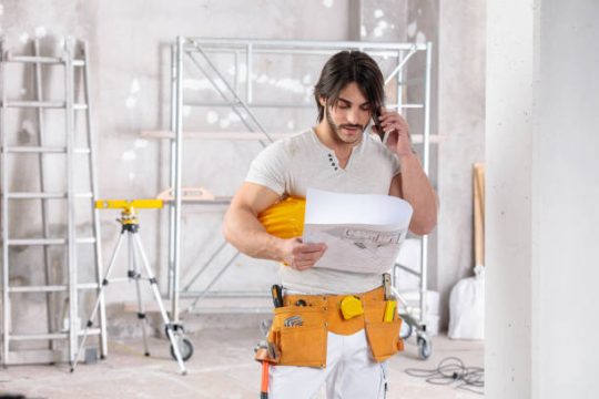 Tradesperson checking drawings near kwikstage scaffolding system