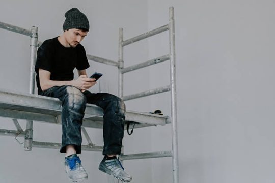 young worker sitting on kwikstage scaffolding during break
