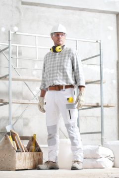 construction worker standing in front of kwikstage scaffolding system supplied by GW Equip