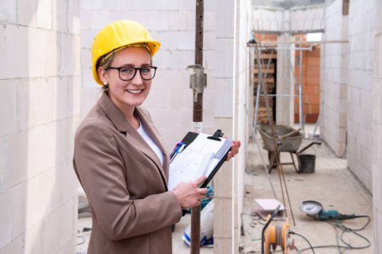 Construction site supervisor checking mobile scaffold safety during building work