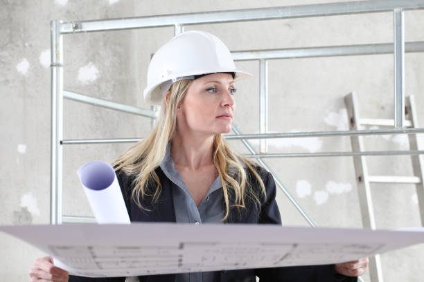 Site supervisor reviewing plans beside mobile scaffolding during construction work
