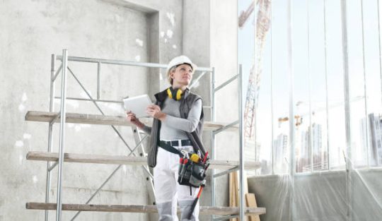 Worker using mobile scaffold platform for indoor construction and maintenance work