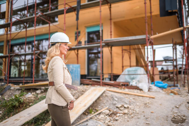 Builder inspecting scaffolding outside a multi-storey residential building
