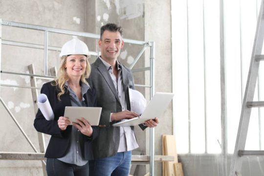 Construction professionals reviewing scaffold setup with digital plans